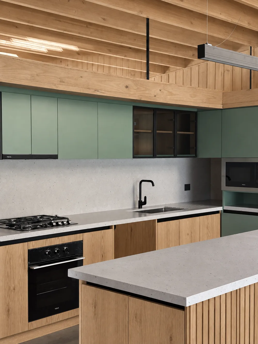 Casa Almares — cocina y comedor abiertos bajo el cielo de vigas de madera, con isla central