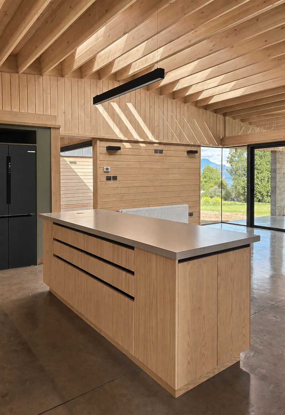 Casa Almares — cocina con isla de madera y luz de tarde hacia el jardín