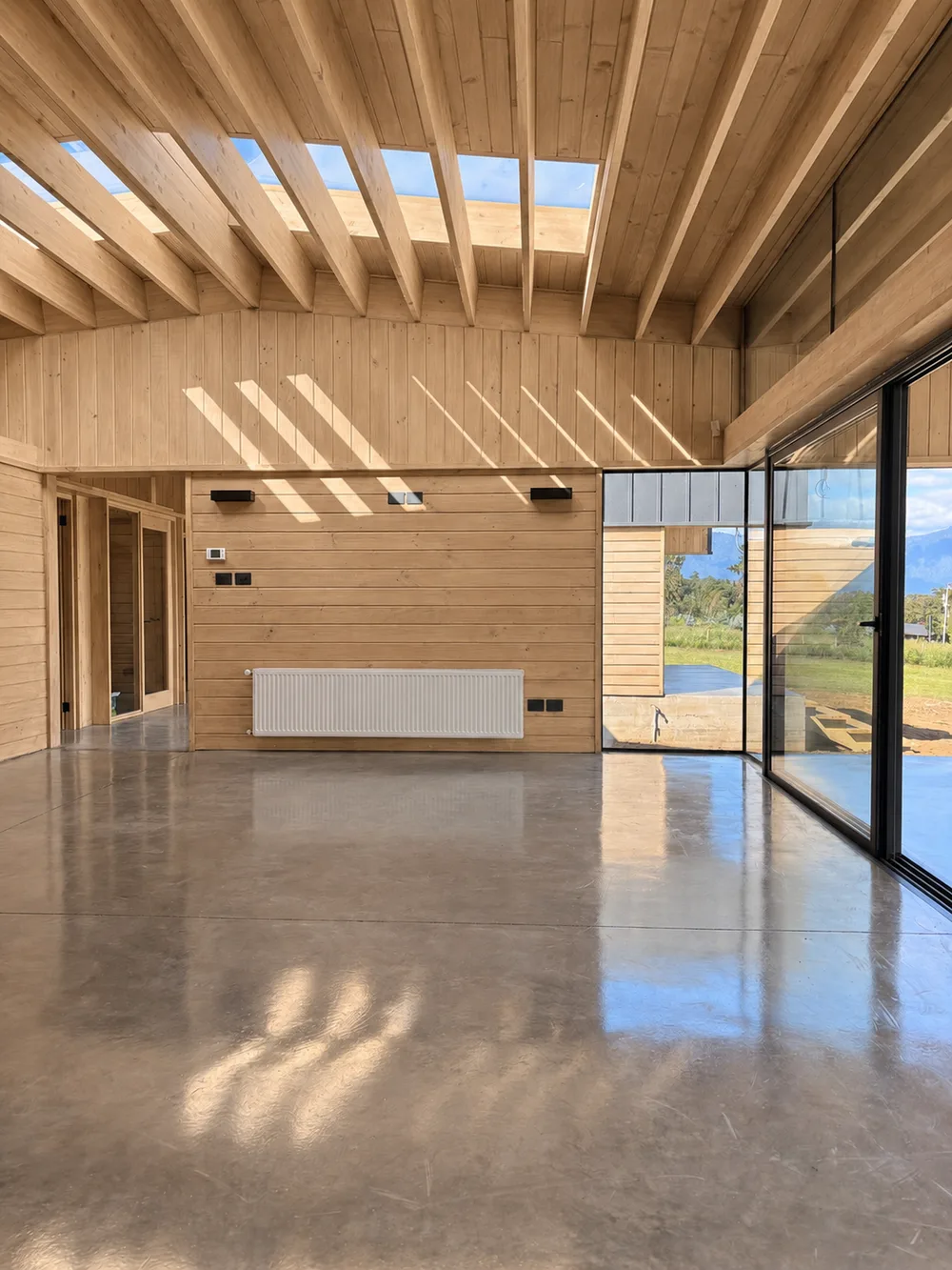 Casa Almares — estar con muro revestido en madera y ventanal continuo hacia el paisaje