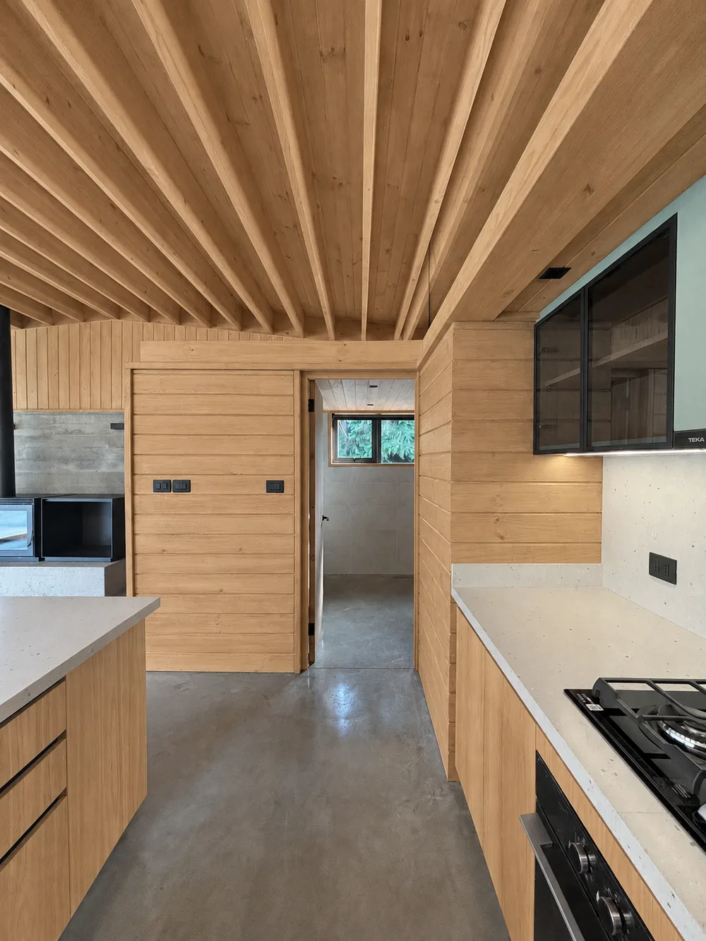 Casa Almares — paso de servicio revestido en madera junto a la cocina