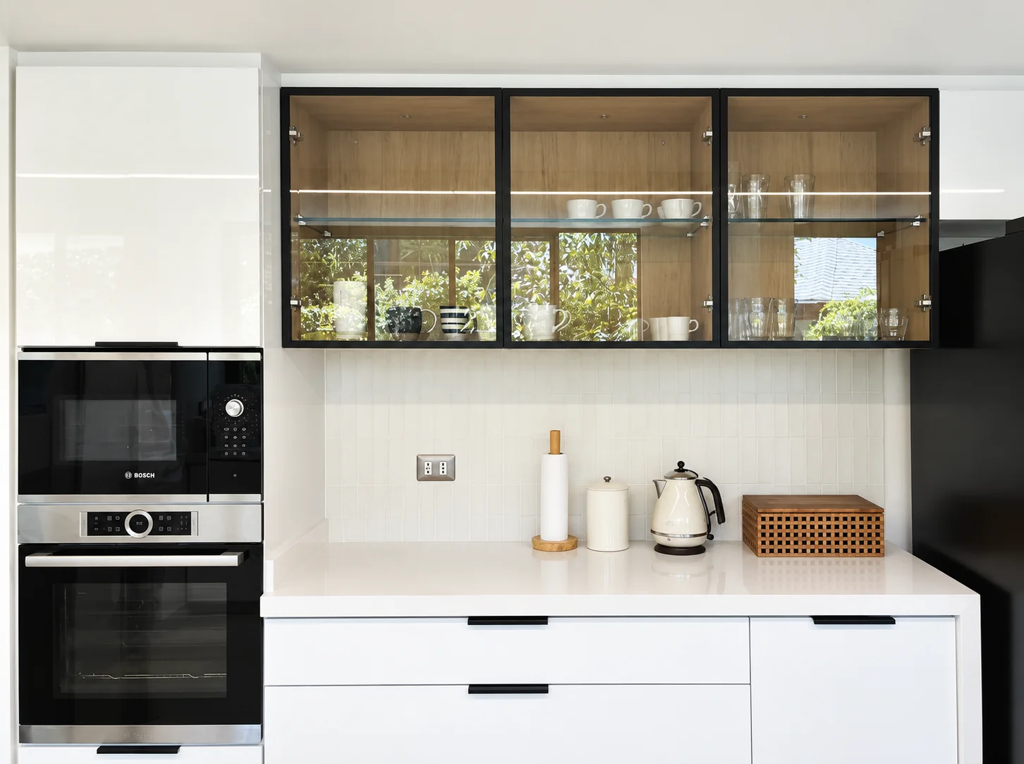 Casa Buenaventura — cocina con muebles blancos y vitrina de vidrio