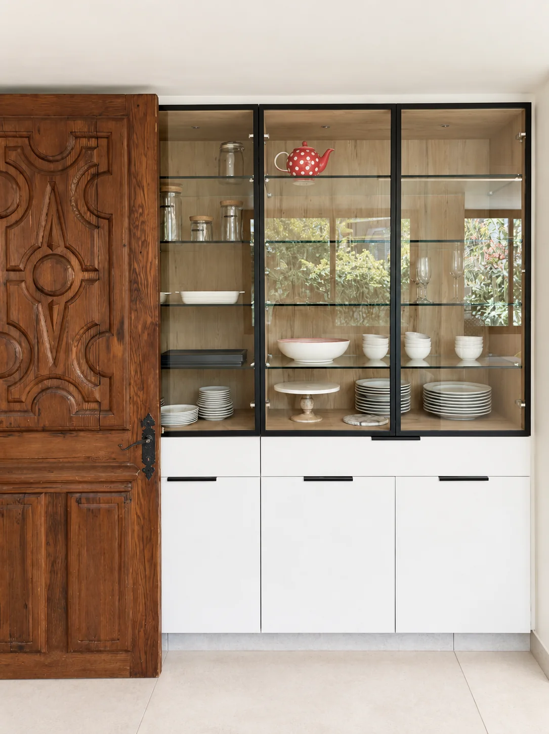 Casa Buenaventura — vitrina de cocina junto a puerta de madera tallada