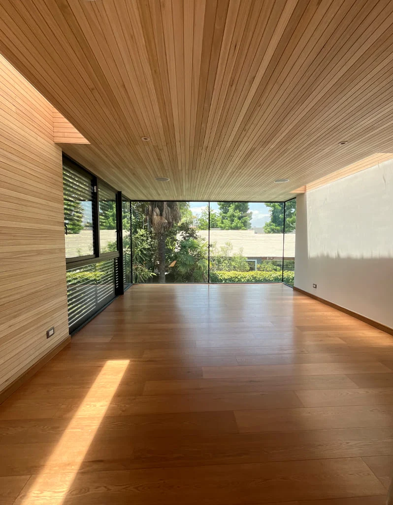 Casa Buenaventura — estar con esquina vidriada, continuidad interior-exterior