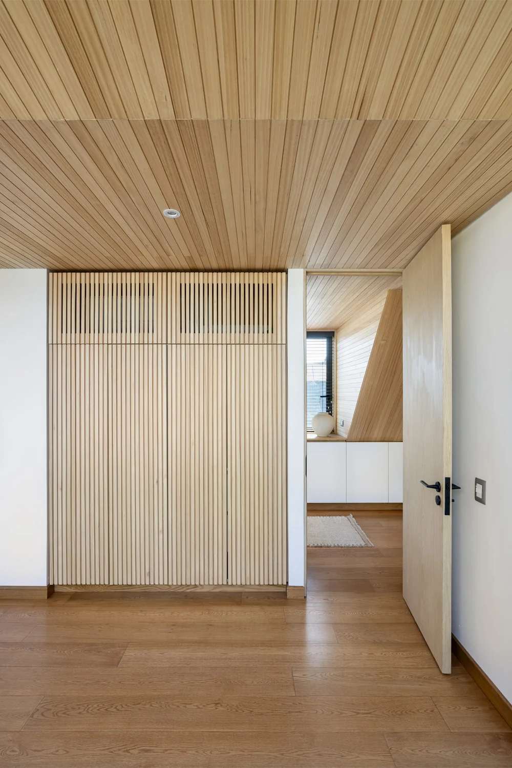 Casa Buenaventura — pasillo con el muro de listones de madera y cielo entablado
