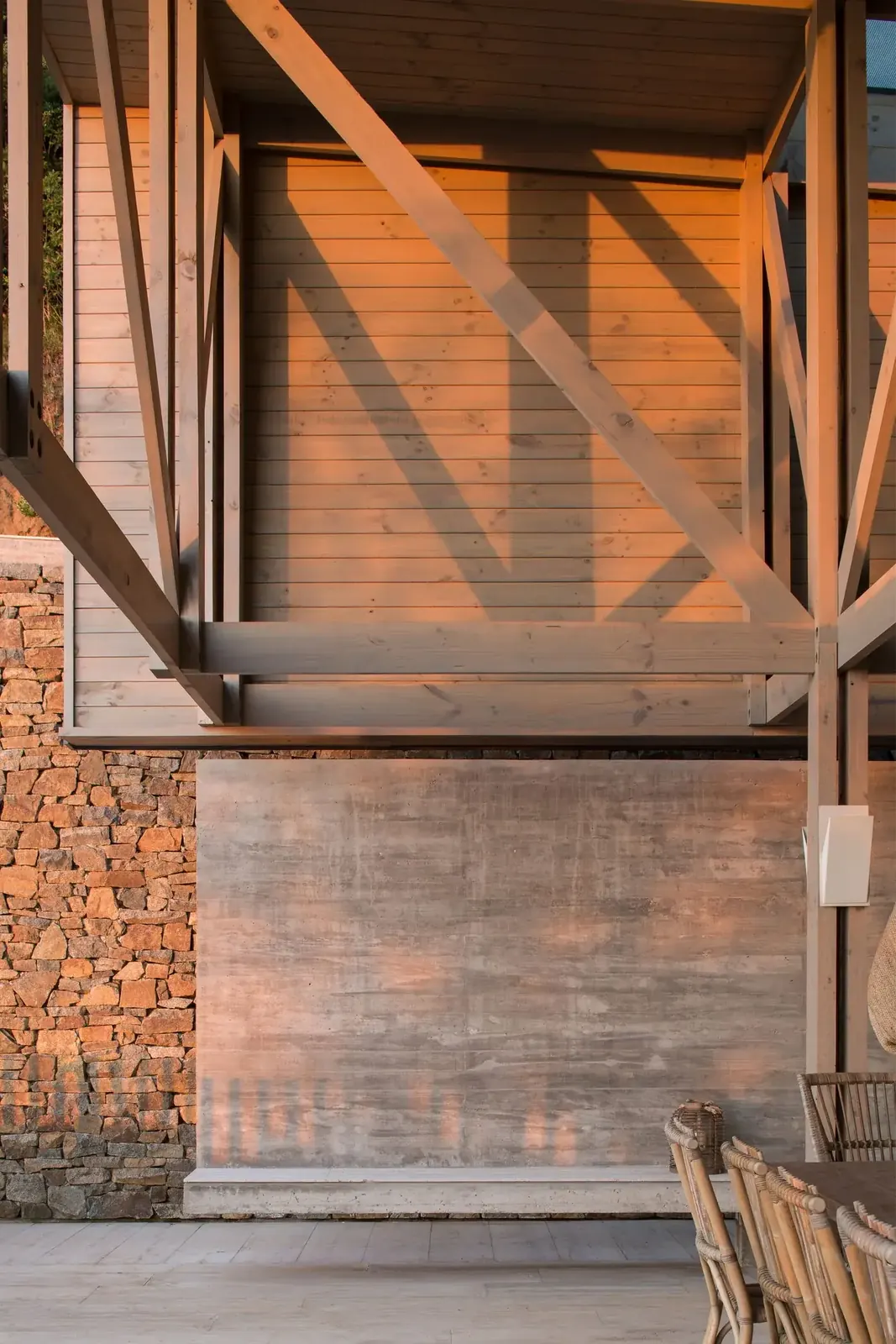 Casa 59 — detalle de la estructura de madera, hormigón y muro de piedra