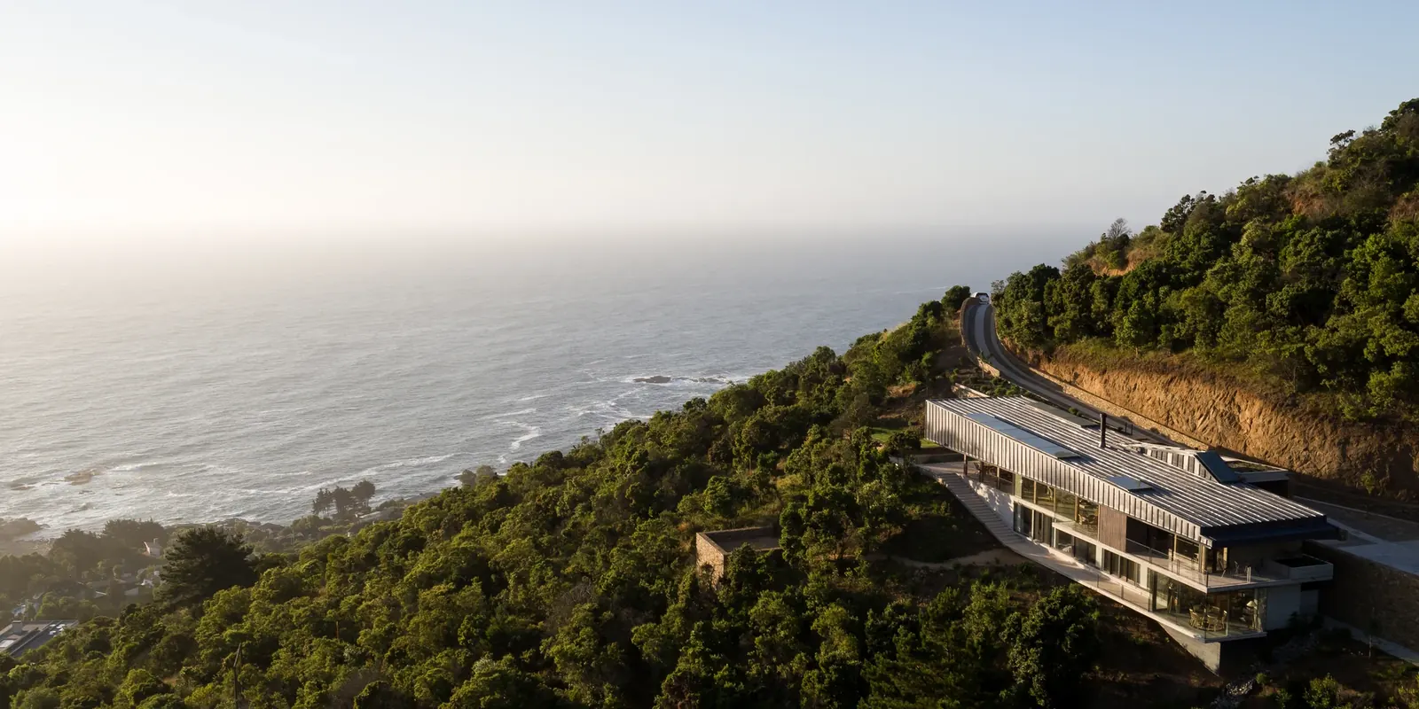 Casa 59 — vista aérea de la casa en la ladera sobre el mar