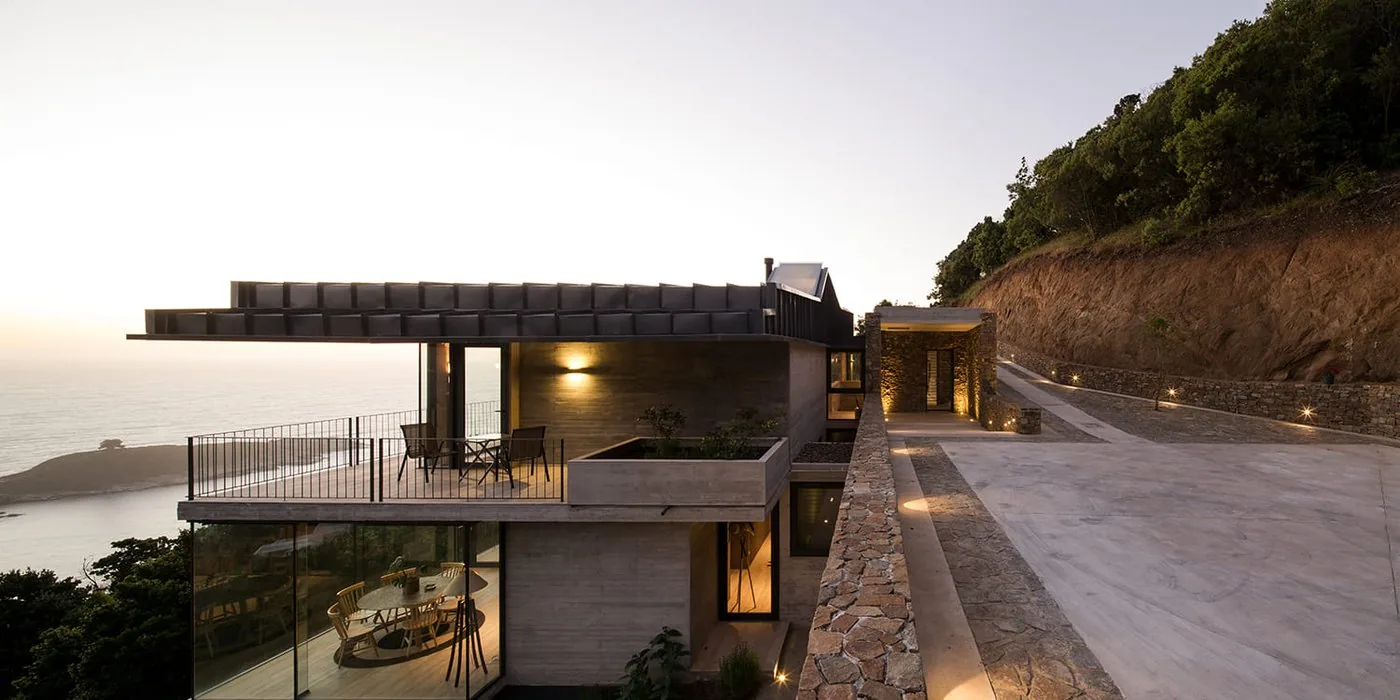 Casa 59 — vista lateral de la casa en la ladera sobre el mar
