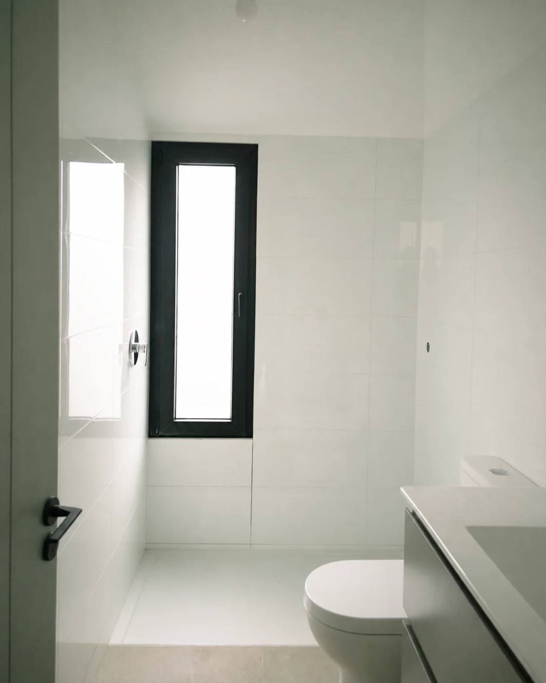 Casa Apolo — baño con ventana vertical y vanitorio blanco