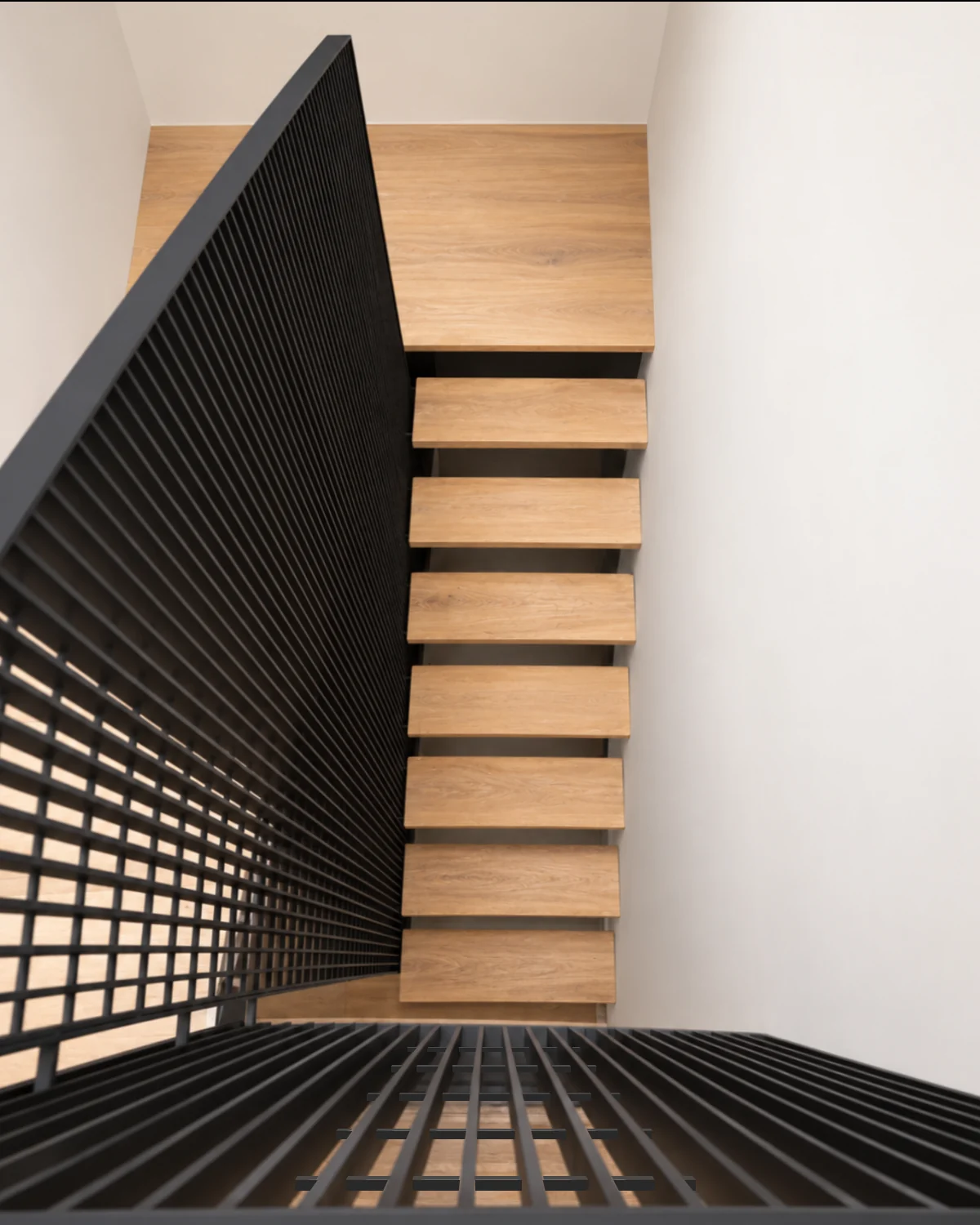 Casa Apolo — escalera de madera vista desde arriba con baranda metálica