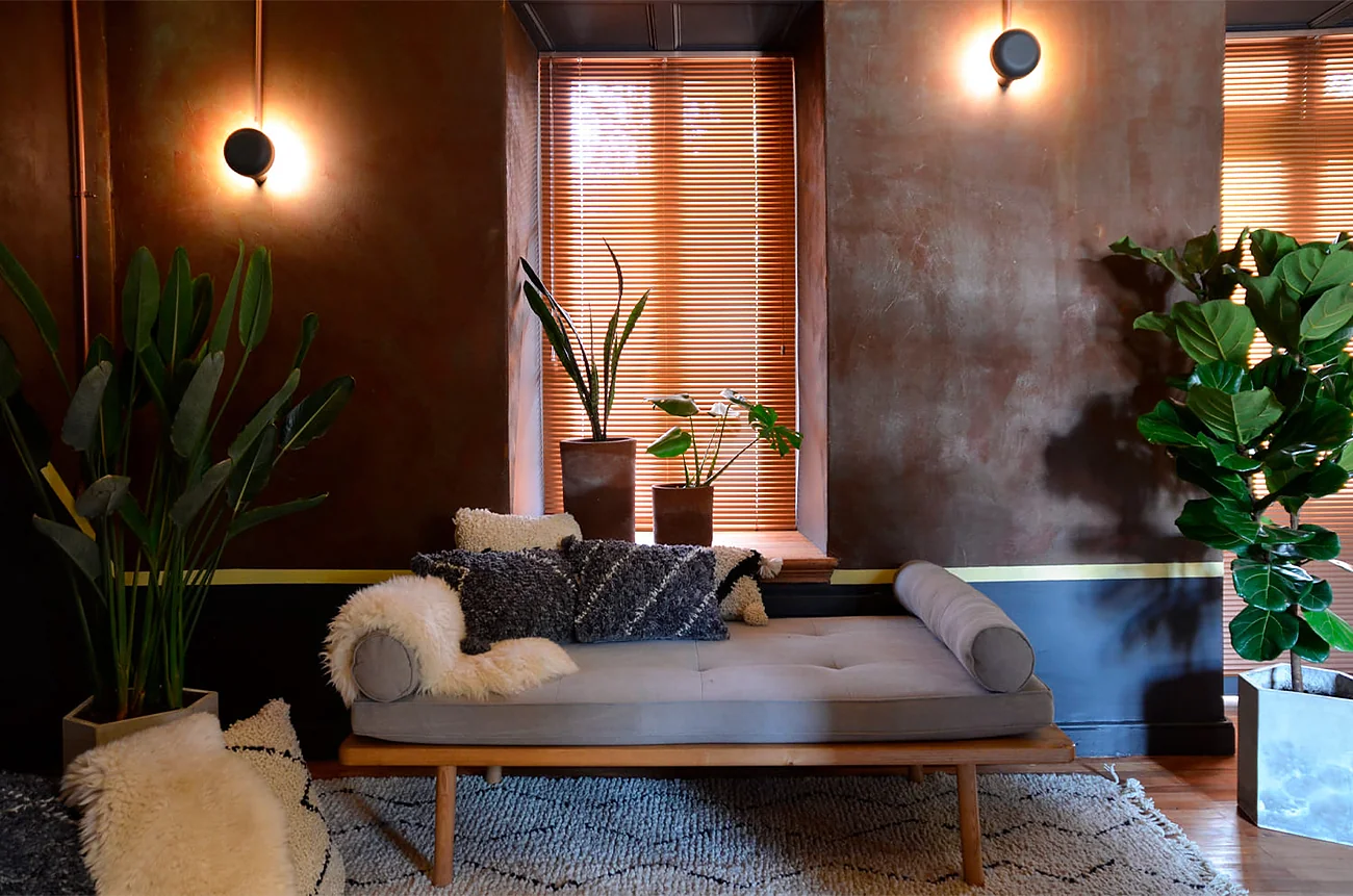 Sala Pausa — sofá, textiles y ventanas de madera