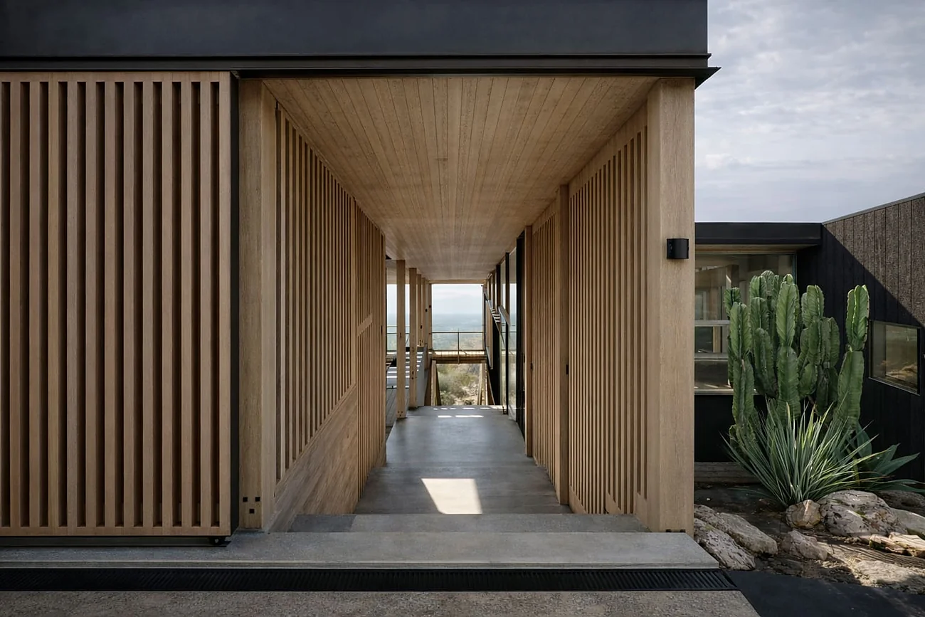 Casa KB — acceso a la vivienda entre los volúmenes de madera