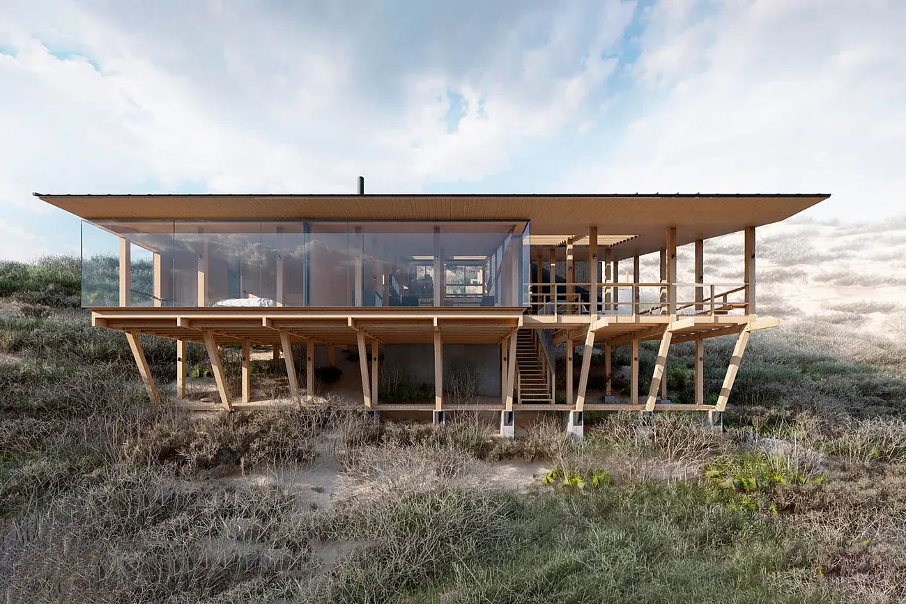 Casa KB — vista frontal de la estructura de madera apoyada sobre pilotes en la ladera