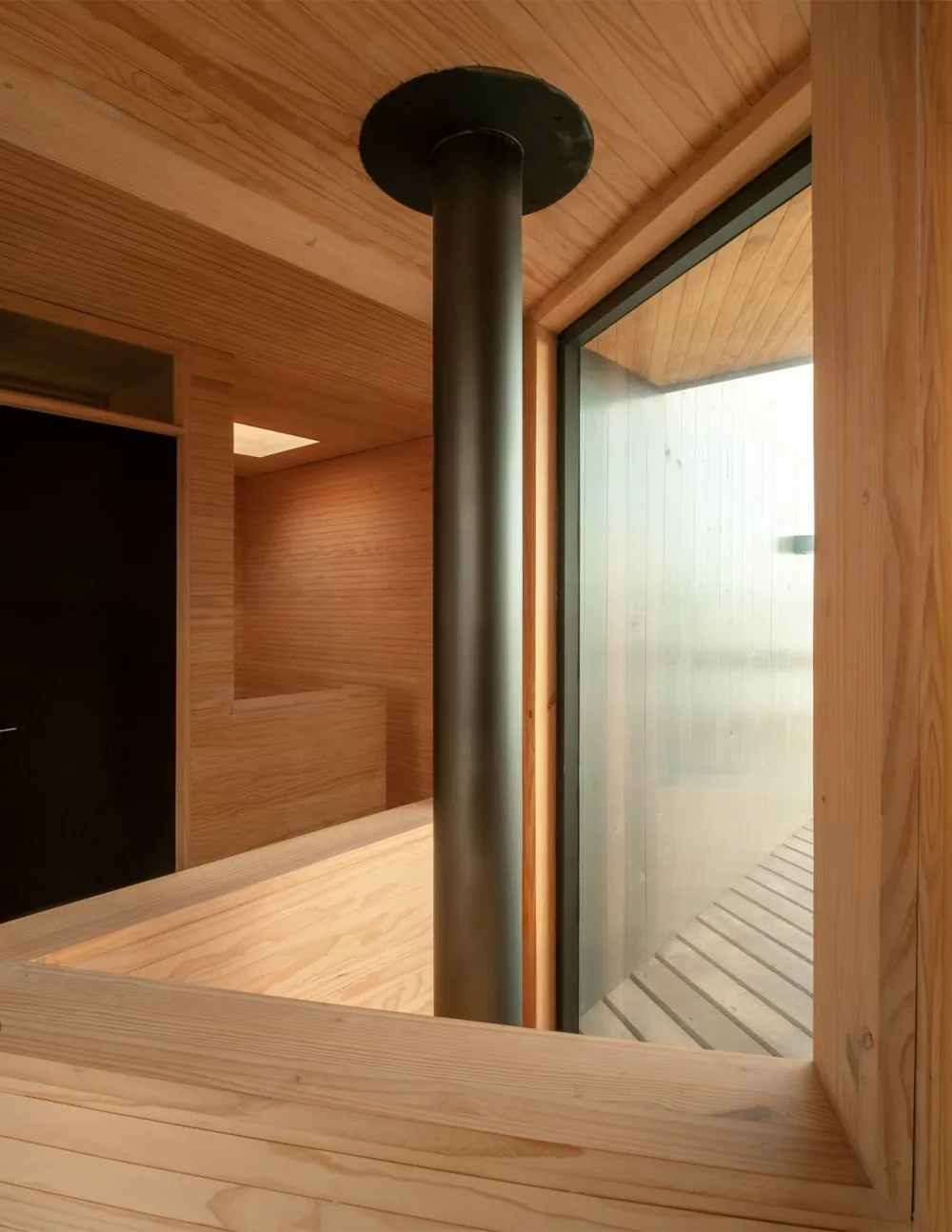 Casa Laguna — detalle de la chimenea de acero, vidrio y madera