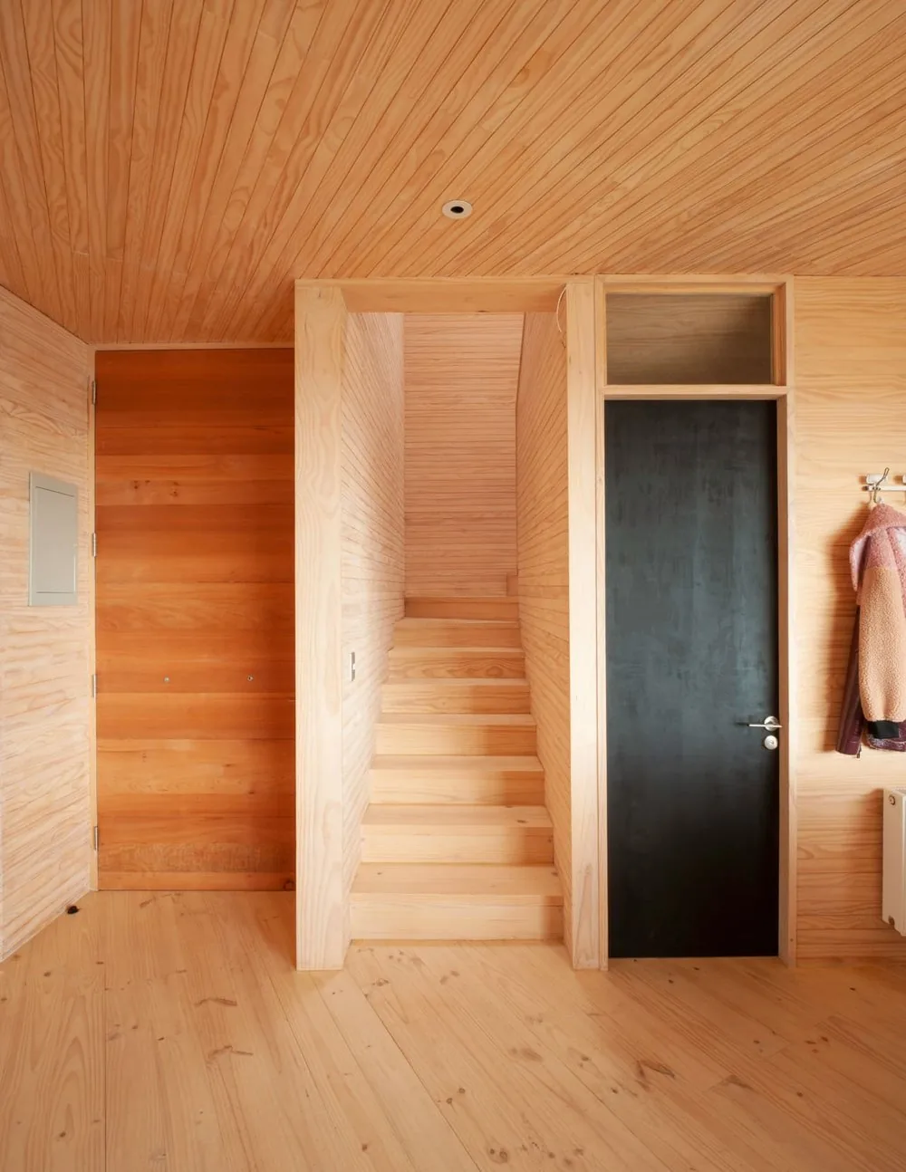 Casa Laguna — escalera interior revestida en madera