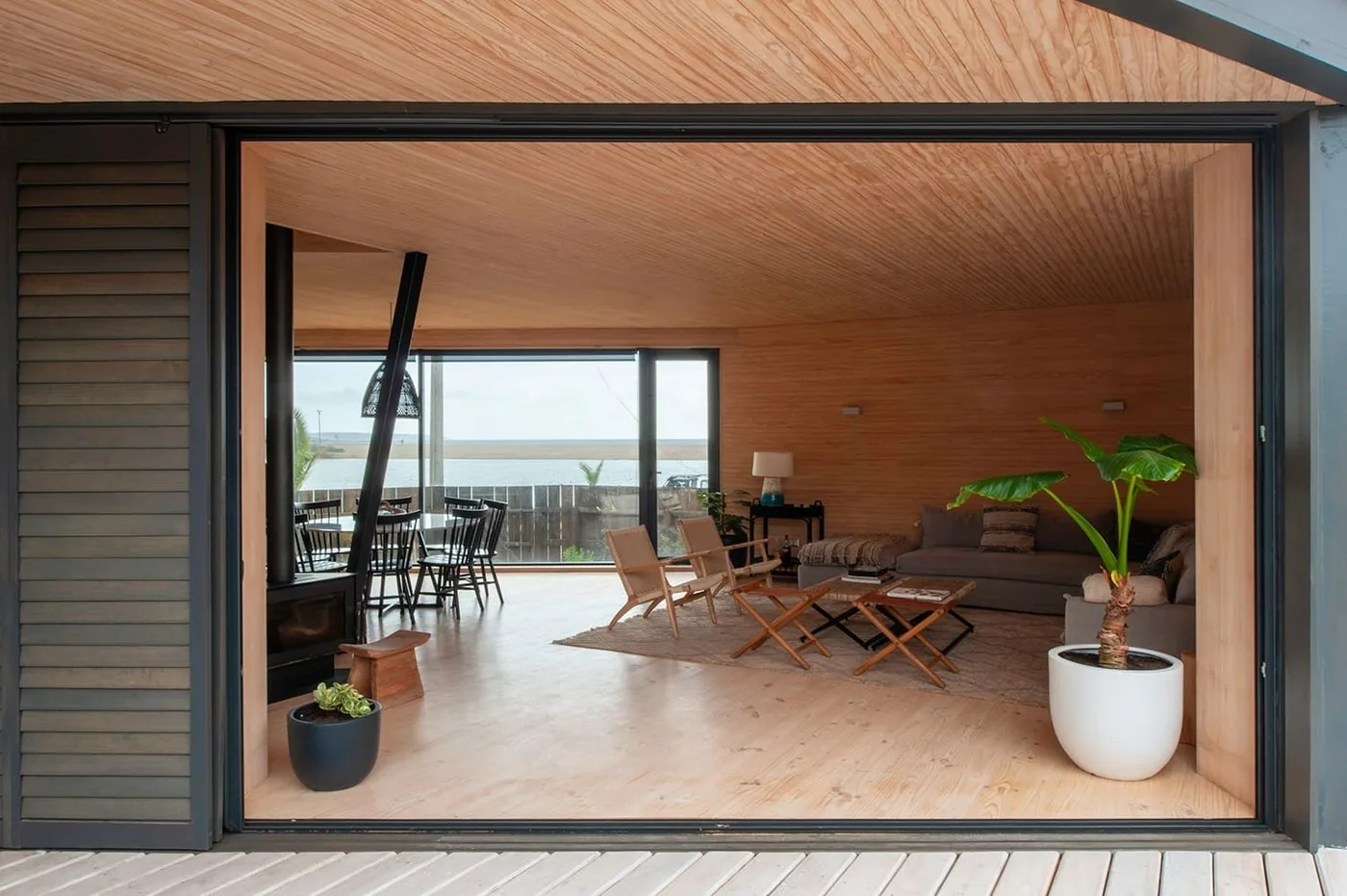 Casa Laguna — estar interior abierto a la terraza con vista al agua