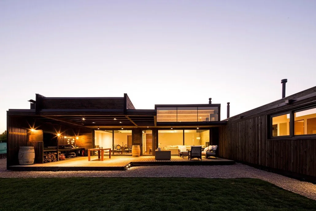 Casa TH — fachada interior nocturna con terraza y quincho iluminados