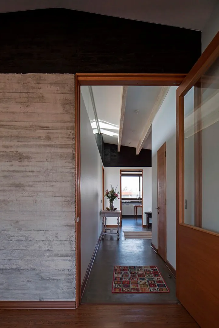 Casa TH — hall de circulación con muro de hormigón y tabique de madera