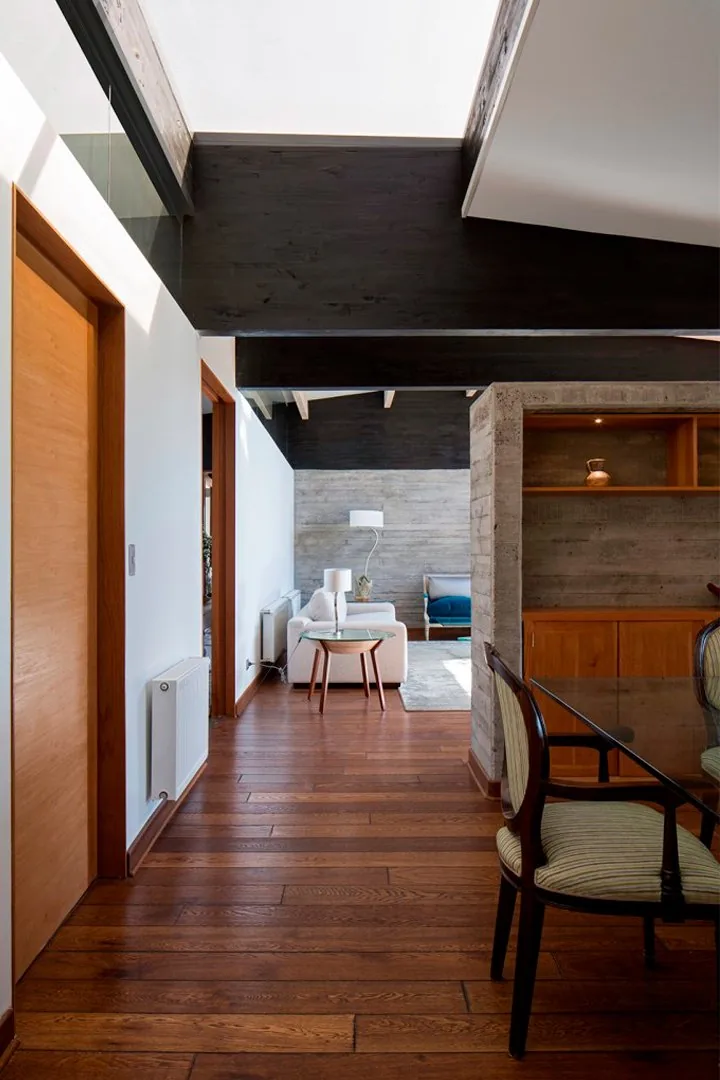Casa TH — pasillo interior con cielo de madera y muro de hormigón a la vista