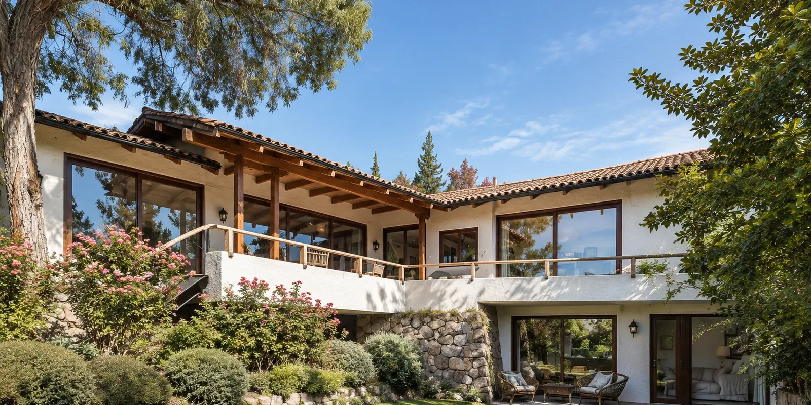 Casa Fernández Vial, Lo Barnechea — fachada de la casa tradicional con terraza cubierta de madera sobre el jardín