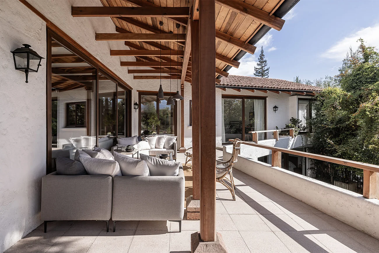 Casa Fernández Vial — terraza cubierta bajo la estructura de vigas de madera, con vista al jardín