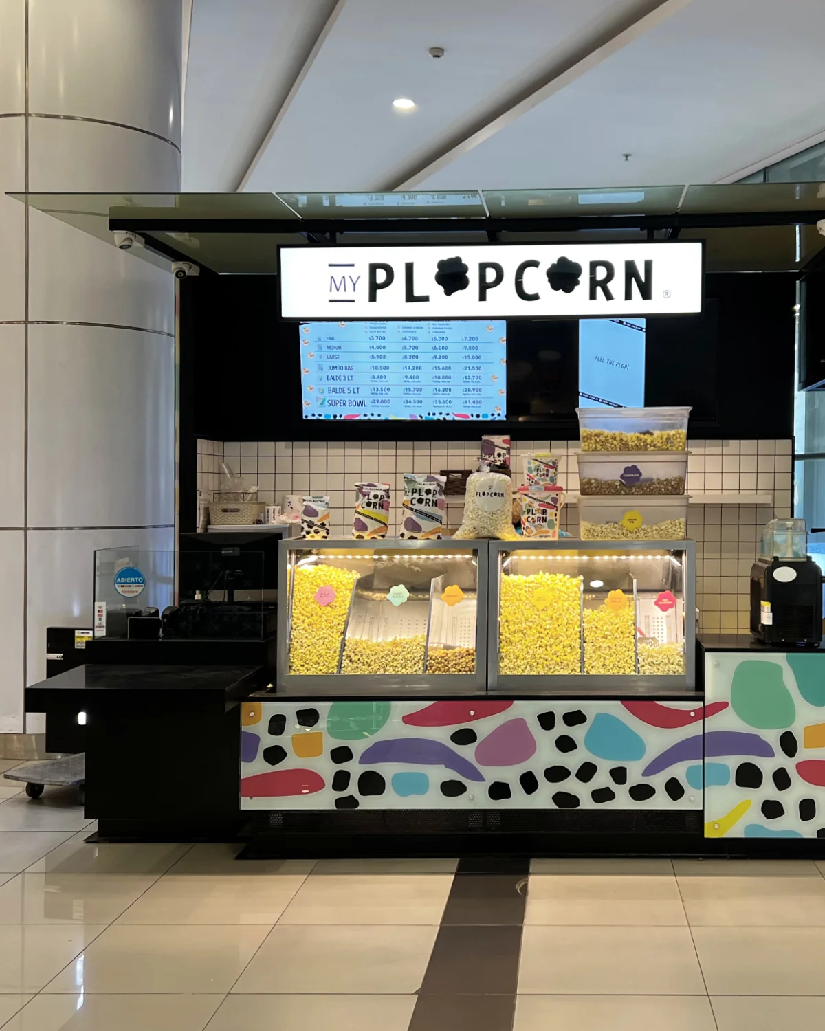 Plop Corn — frente del módulo con estructura negra y letrero luminoso