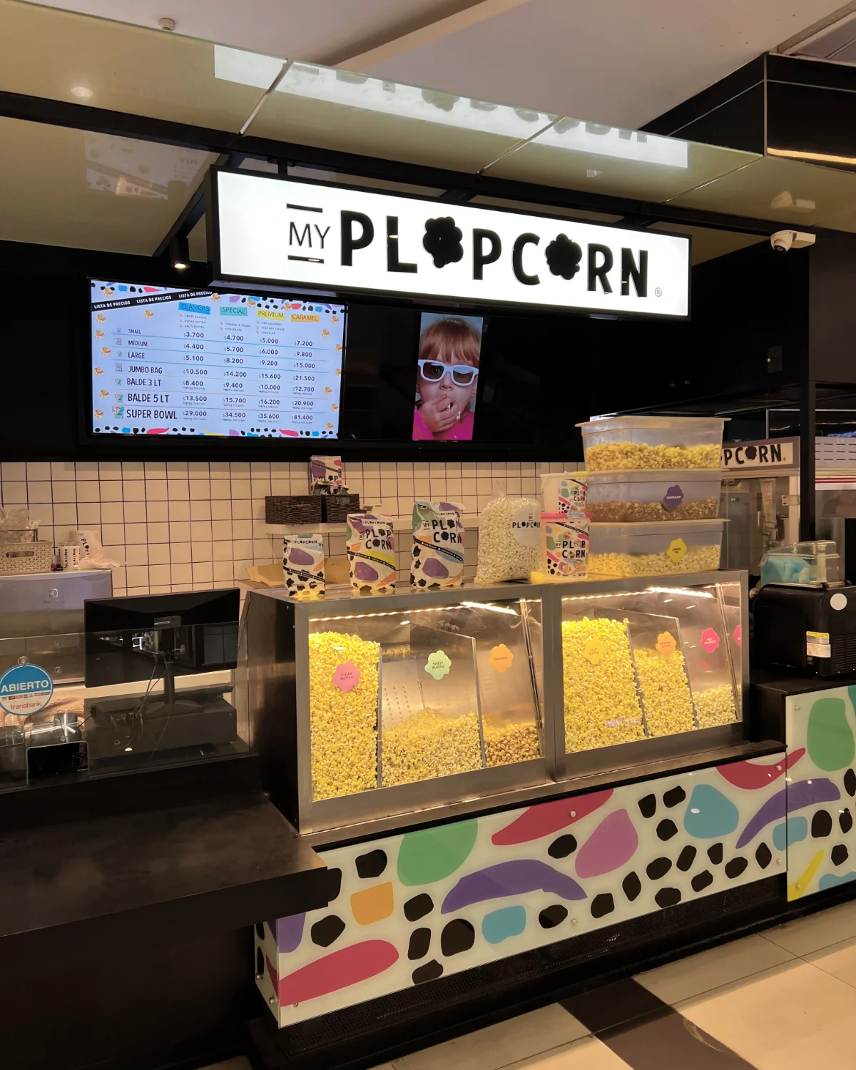 Plop Corn — vitrina con exhibidor de cabritas y frente con gráfica de colores